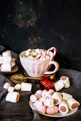 Good New Year spirit. Coffee with marshmallows and cinnamon. Candy canes. Pink mug. Cooking yourself. Home comfort. New Year. Christmas time. Winter mood.