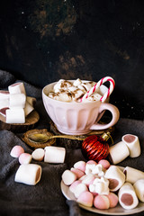 Obraz na płótnie Canvas Good New Year spirit. Coffee with marshmallows and cinnamon. Candy canes. Pink mug. Cooking yourself. Home comfort. New Year. Christmas time. Winter mood.