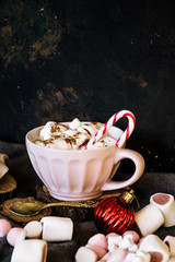 Good New Year spirit. Coffee with marshmallows and cinnamon. Candy canes. Pink mug. Cooking yourself. Home comfort. New Year. Christmas time. Winter mood.