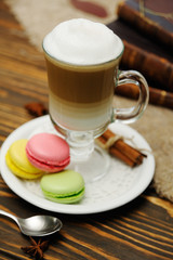 latte and macaroons close-up on a wooden background on a background of old books and burlap