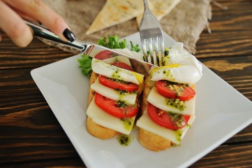 breakfast bread with egg poached, tomato, cheese and greens close-up on a wooden background