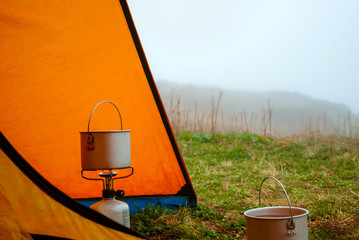 foggy morning in the hike, the view from the tent to the clearing, the hiking pot stands on portable gas burner