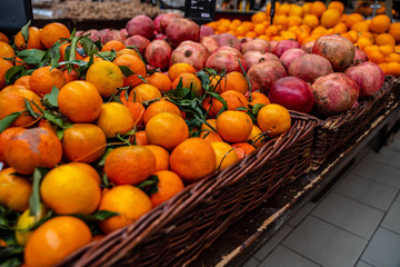 Mangerines and pomegranates for sale at the market in a wicker basket. Perfect for Background