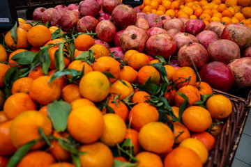 Mangerines and pomegranates for sale at the market in a wicker basket. Perfect for Background