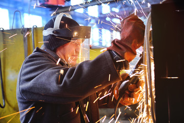 Worker with angle grinder.Sparks from welding or from a torch for metal