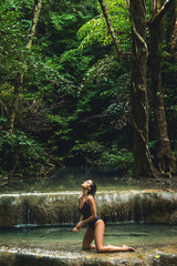Sexy woman in the jungle with beautiful waterfall