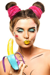Beautiful model with creative pop art makeup holding banana