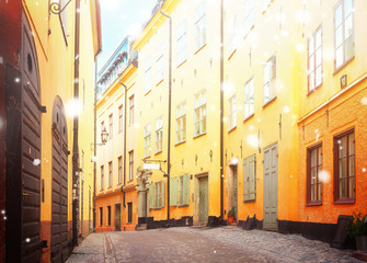 Fototapeta na wymiar view of old town street in Stockholm at sunny day with snow, Sweden