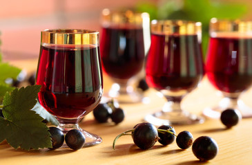 Homemade black currant liqueur and fresh berries.