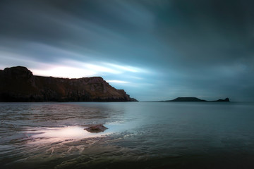 Long exposure on the clouds at Rhossili Bay and Worms Head on the Gower peninsula, Swansea, South Wales, UK