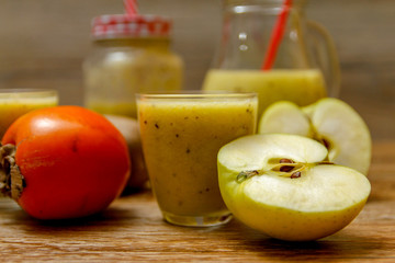Freshly blended fruit smoothie with fresh fruits on wooden table with raw fruits