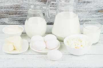 Different dairy products on the white wooden boards