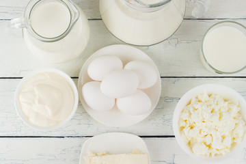 Different dairy products on the white wooden boards
