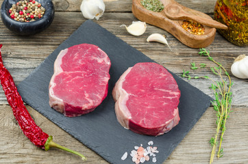 Fresh raw beef steak with spices. Raw steak.  Fresh raw prime black angus beef steaks on black...