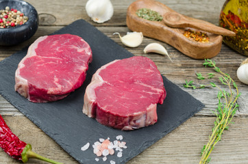 Fresh raw beef steak with spices. Raw steak.  Fresh raw prime black angus beef steaks on black board 