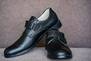 Black leather shoes for boy. Classic boys children's new black school shoes on grey background.