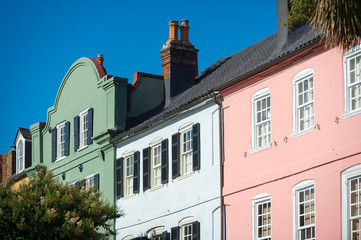 Brightly colored colonial architecture lining the historical Battery neighborhood under blue sky in Charleston, South Carolina, USA