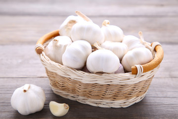 Fresh garlic in basket on a grey wooden background