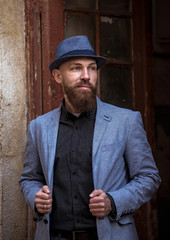 stylish man with a beard in a hat on the street