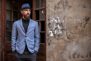 stylish man with a beard in a hat on the street