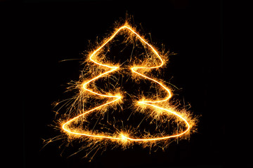 Christmas tree drawing sparkling sparklers on black background
