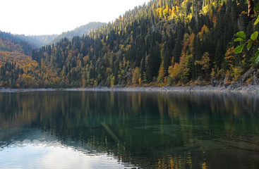 Beautiful lake surrounded by mountains and forests in autumn. Malaya Ritsa, Abkhazia.