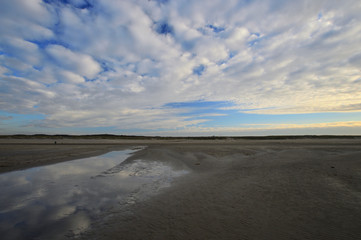 Fototapeta na wymiar Nadmorskie wybrzeże, plaża i morze pod niebieskim niebem z chmurami.