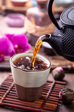 Black tea pouring into cup, oriental style