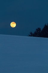 Vollmond über Winterlandschaft in der Nacht