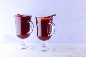 Mulled wine on white background. Christmas mulled wine, cinnamon sticks, anise and honey. Alcoholic drink of wine, fruit and honey. Festive drink and Christmas tree branches