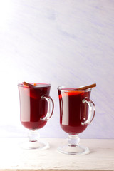 Mulled wine on white background. Christmas mulled wine, cinnamon sticks, anise and honey. Alcoholic drink of wine, fruit and honey. Festive drink and Christmas tree branches