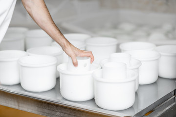 White plastic molds with fresh cheese ready for pressing at the cheese manufacturing