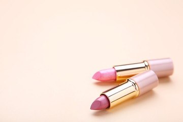 Obraz na płótnie Canvas Two lipsticks on beige background, close up