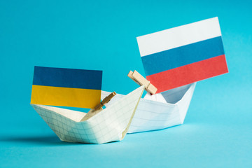 paper ships with flags of Ukraine and Russia, symbol of conflict at sea 