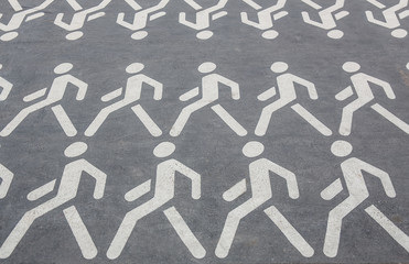 pictograms of people walking in rows on the asphalt