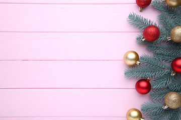 Fototapeta na wymiar Christmas decoration. Fir-tree branch with balls, bows on a pink background