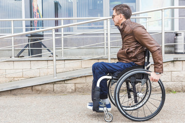 Obraz premium Man in a wheelchair use a wheelchair ramp.