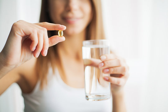 Vitamins And Supplements. Woman Taking A Tablet. Close Up Hand With A Pill And The Mouth.