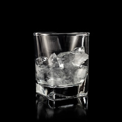 glass for alcohol with pure ice isolated over black background