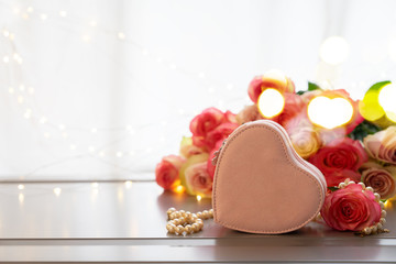 Rose fresh flowers bouquet on gray table by the window with heart gift box and with bokeh lights