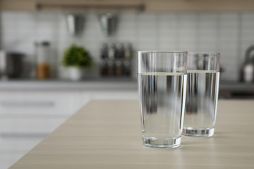 Glasses of fresh water on table indoors. Space for text