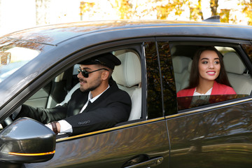 Young businesswoman with handsome driver in luxury car