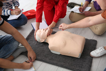 Group of people with instructor at first aid class indoors, closeup
