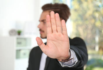 Fototapeta Man showing stop gesture in office. Problem of sexual harassment at work obraz