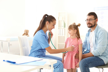 Obraz premium Children's doctor examining little girl with stethoscope in hospital