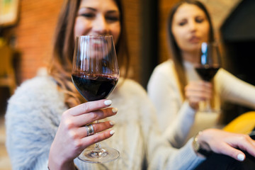 young women with glasses of wine in restaurant