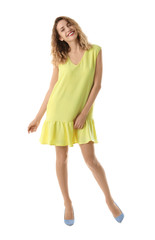 Young woman with beautiful long legs in stylish outfit on white background