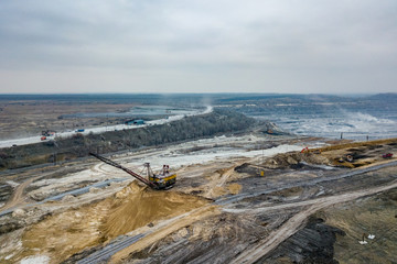 Fototapeta na wymiar Open pit mine, aerial view from drone. Working excavators and dump trucks