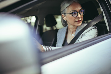 Senior woman driving a car in the city