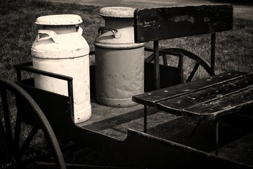 Old milk jugs on a wagon.